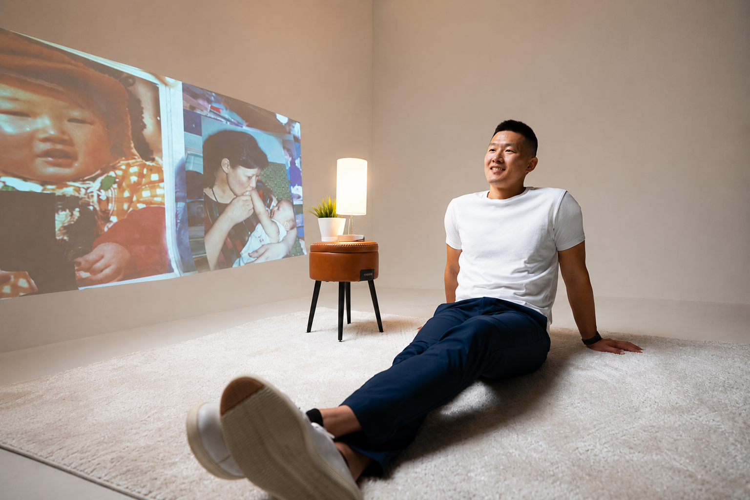 Don Chen seated beside projected family photographs